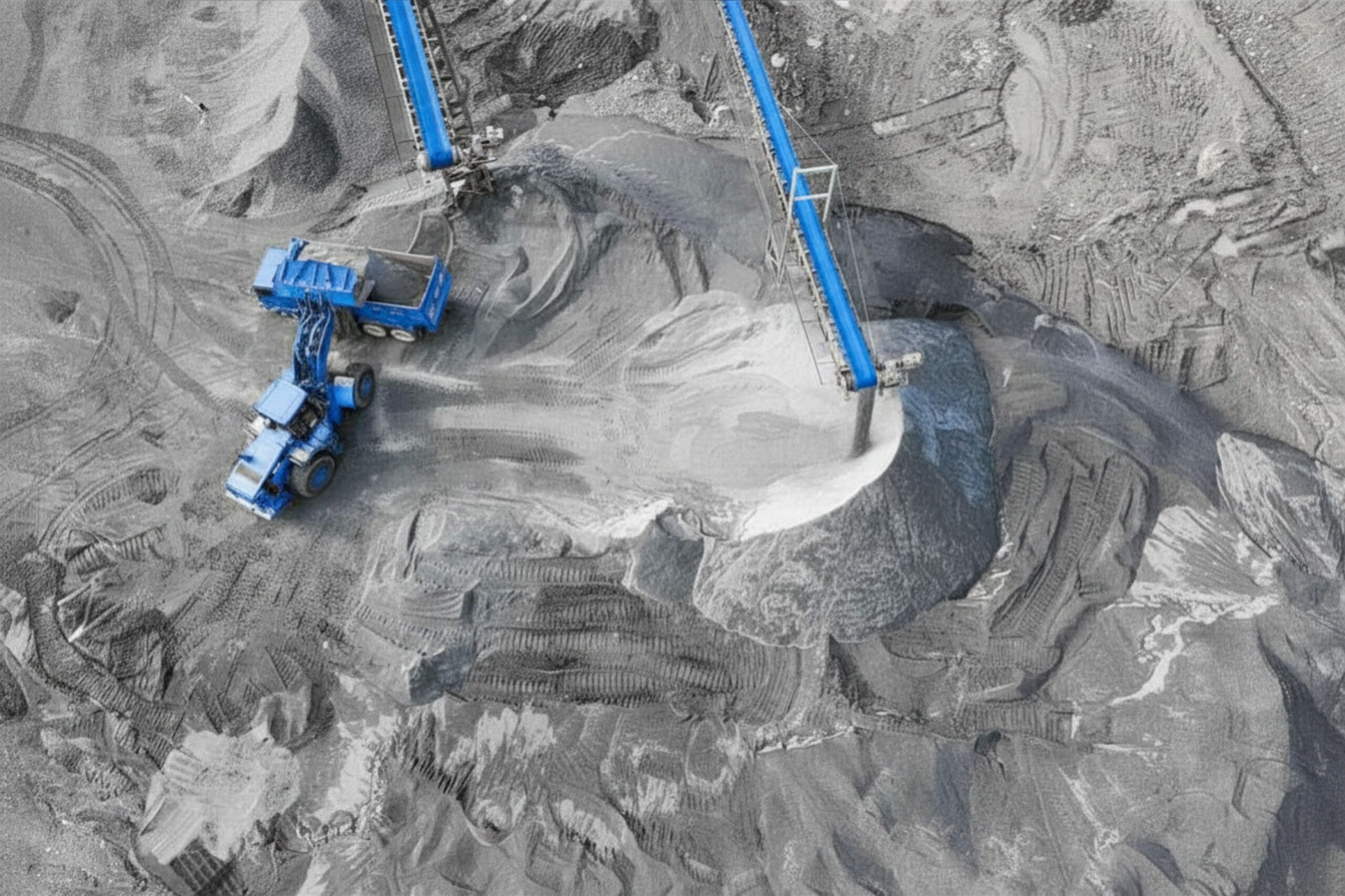 Aerial view of an open pit mining operation with conveyors, stockpiles and haul trucks