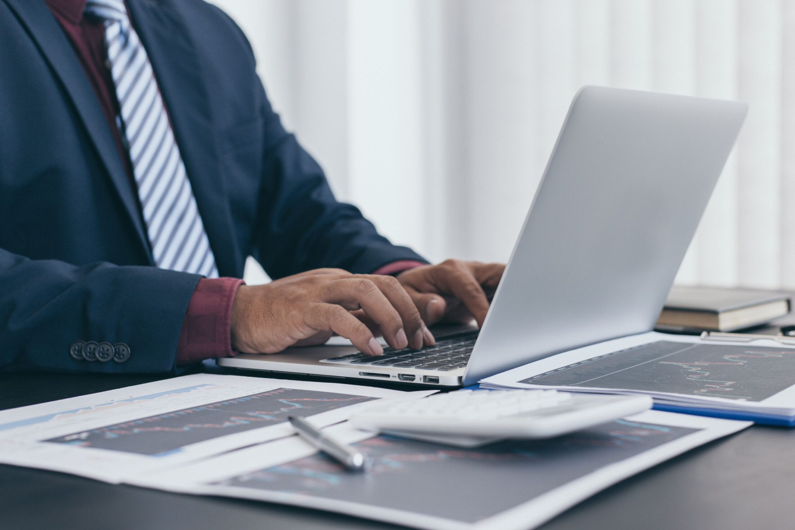 Mining executive reviewing production and financial reports on a laptop